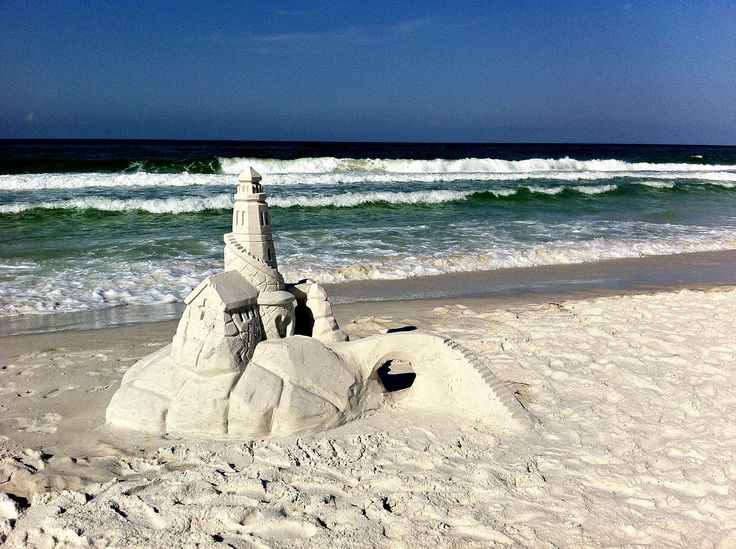 a sand castle on the beach with waves in the background