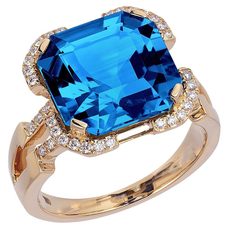 This London Blue Topaz Emerald Cut Ring in 18K Yellow Gold with Diamonds is a stunning piece of jewelry from the 'Gossip' Collection. The ring features a deep blue, emerald-cut London Blue Topaz center stone that is beautifully complemented by a halo of sparkling diamonds set in 18K yellow gold. The diamonds extend down the sides of the band, adding extra shimmer and elegance. This ring is the perfect choice for anyone looking for a statement piece that combines classic and modern design element Topaz And Diamond Ring, Emerald Cut Ring, Sapphire Cocktail Ring, Fairy Wedding, Fancy Rings, Emerald Cut Rings, Blue Ring, Diamond Collection, Topaz Jewelry