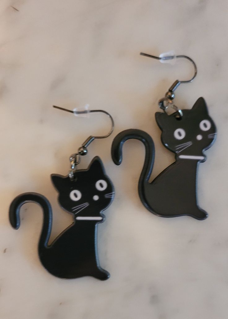 Shiny black cat earrings are super cute and lightweight. Hypoallergenic perfect for a cat lover or Halloween. Makes the perfect inexpensive gift. Trendy Black Halloween Earrings, Black Cat Ears Earrings For Halloween, Cute Cat Ears Earrings With Cat Print, Black Halloween Jewelry With Cat Ears, Black Hypoallergenic Halloween Earrings, Black Hypoallergenic Earrings For Halloween, Black Cat Design Earrings For Halloween, Black Novelty Jewelry With Cat Design, Black Cat Design Drop Earrings