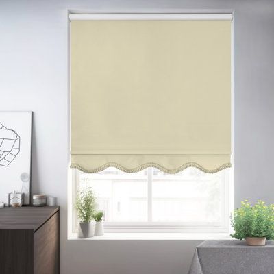 a living room with white walls and a window covered in roman blind shades that have scalloped edges