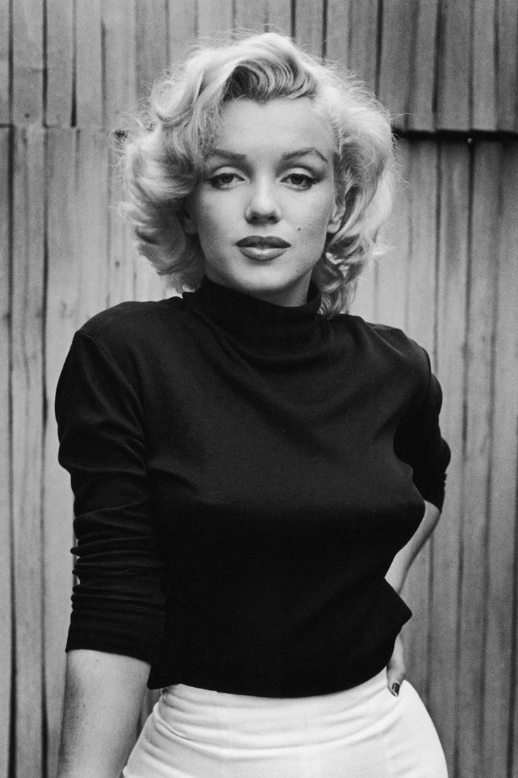 a black and white photo of a woman with blonde hair wearing a turtle neck top