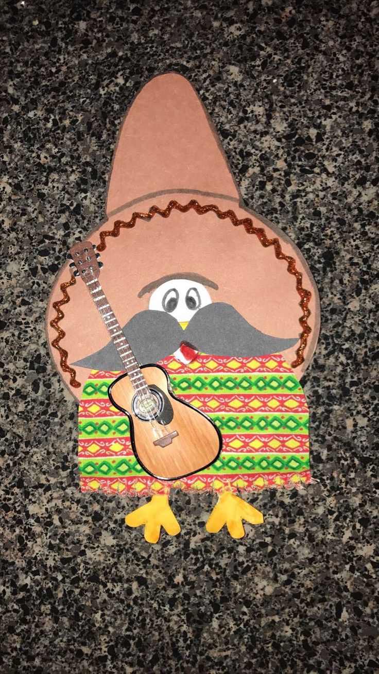 a paper cut out of a turkey with a guitar on it's chest and wearing a sombrero