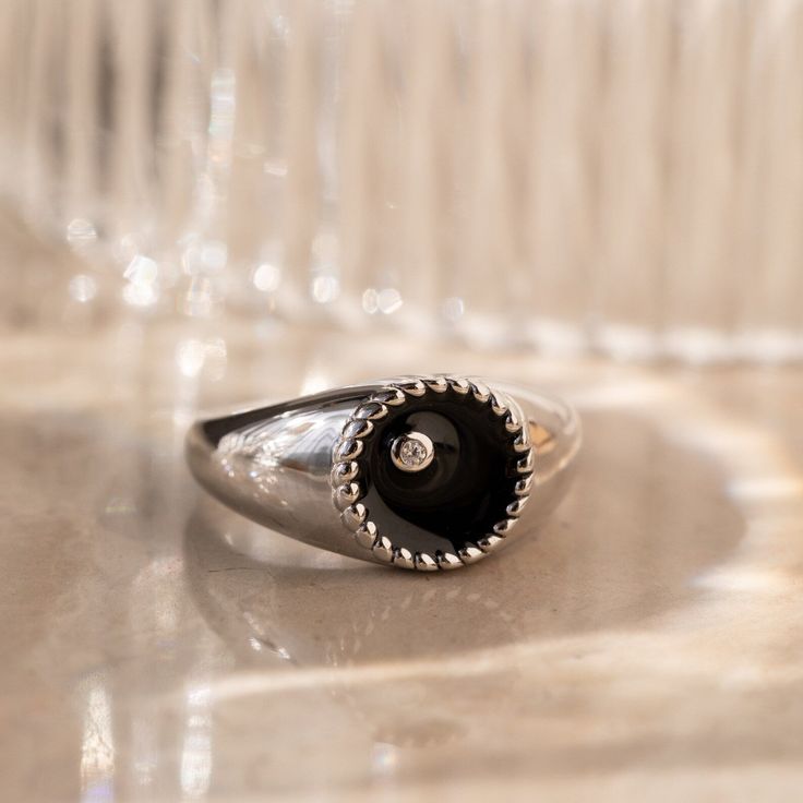 This modern signet ring is sure to get noticed with its bold design and stunning black color. The deep black background and thick ring band is an elegant contrast to the delicately embedded CZ Diamond. It’s both elegant and edgy, making it perfect for any occasion or style. Material: High Quality Solid 925 Sterling Silver Finish: 18K Gold∙Sterling Silver Featuring a ~10mm Black Enamel Signet Ring with an embedded CZ Diamond | Band is ~2.5mm Model showcases a statement, everyday style ring look f Elegant Black Dome Ring With Polished Finish, Classic Black Diamond Ring With Black Enamel, Everyday Black Signet Ring With Polished Finish, Elegant Black Enamel Ring For Promise, Everyday Black Sterling Silver Signet Ring, Modern Black Enamel Signet Ring For Anniversary, Modern Black Diamond Promise Ring, Timeless Black Enamel Signet Ring, Timeless Black Rings With Black Diamonds