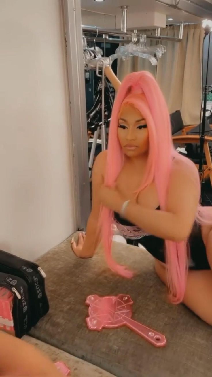 a woman with pink hair sitting on the floor