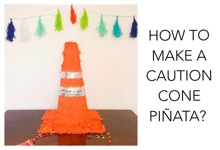 an orange cone sitting on top of a table next to a string of tassels