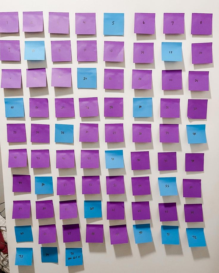 purple and blue post it notes on a white wall