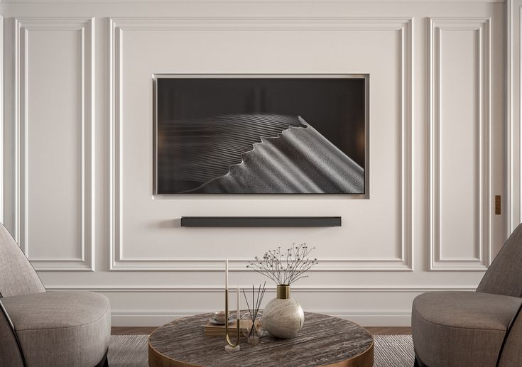 a living room with two chairs and a coffee table in front of a painting on the wall