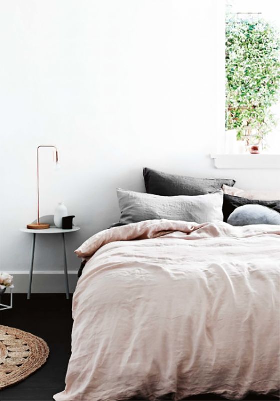 a bed room with a neatly made bed next to a window