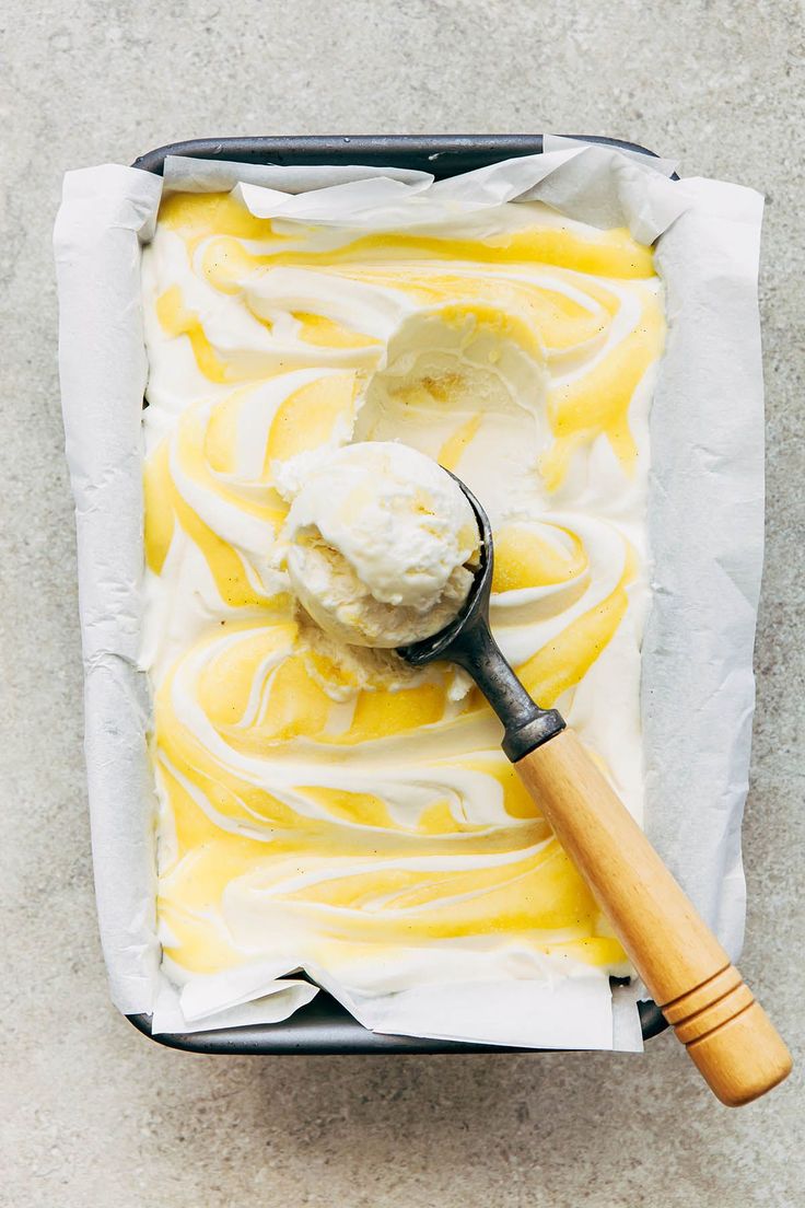 a scoop of ice cream sitting on top of a pan filled with yellow swirled icing