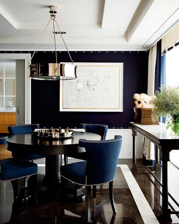 a dining room with blue chairs and a black table