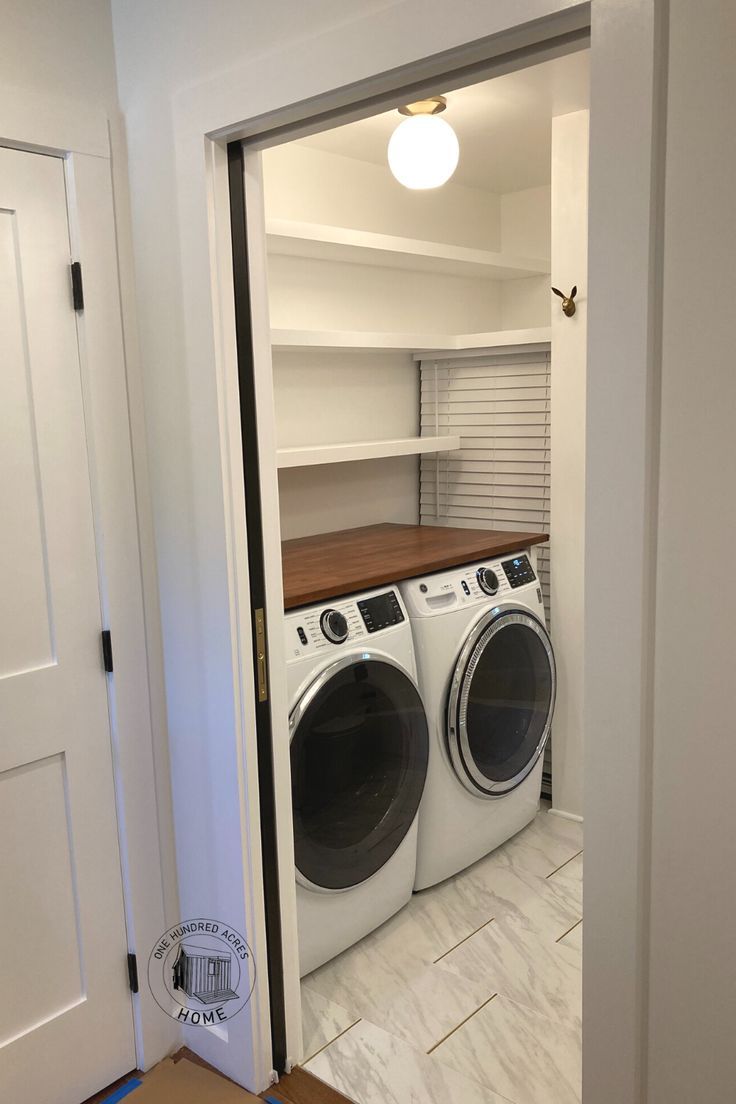 a washer and dryer in a room with open closet doors to the other side