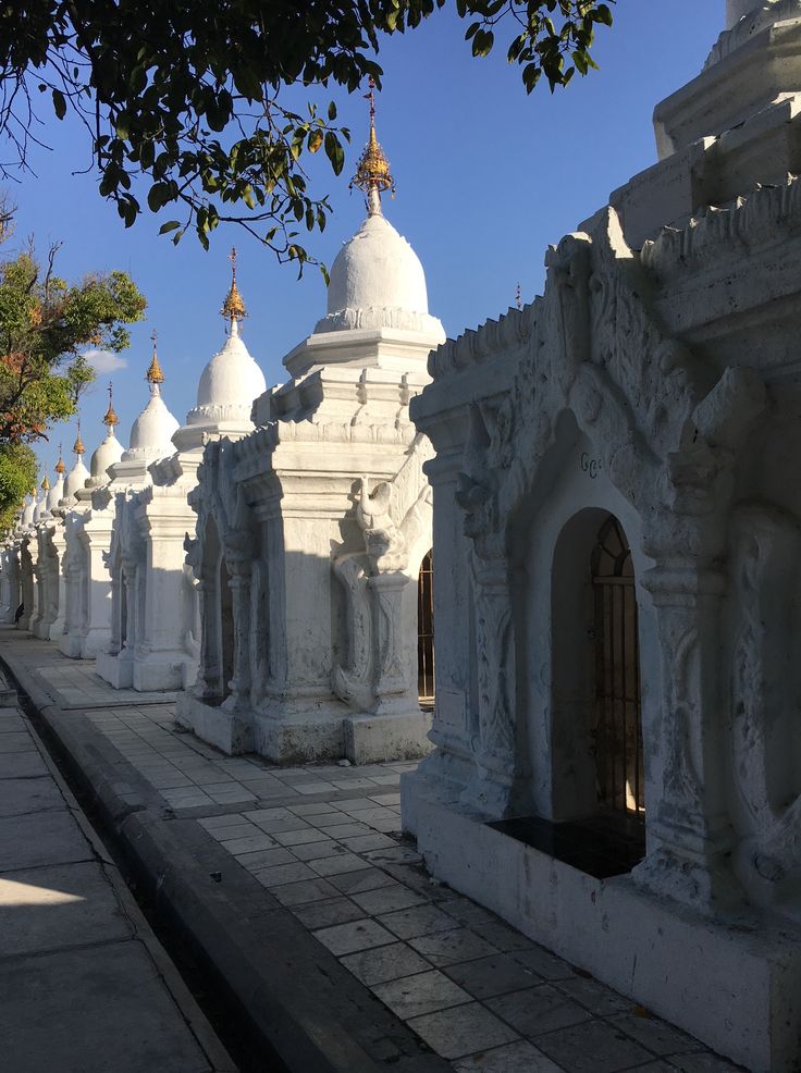 many white buildings are lined up on the sidewalk