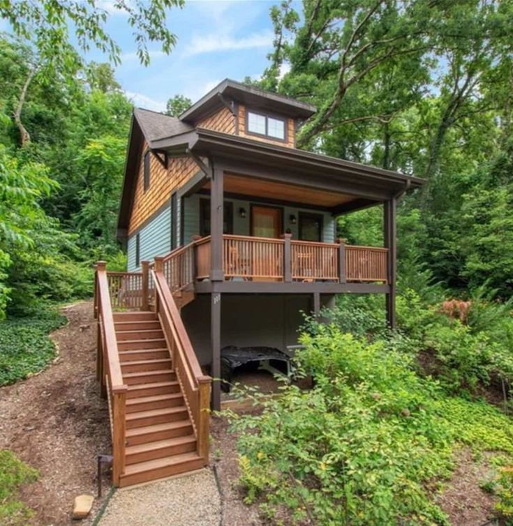 a house in the woods with stairs leading up to it