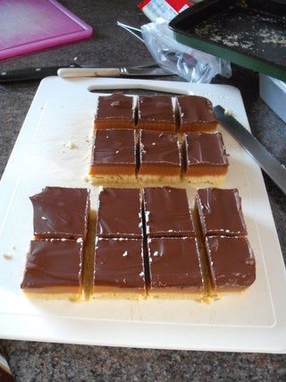 there are several pieces of chocolate on the cutting board