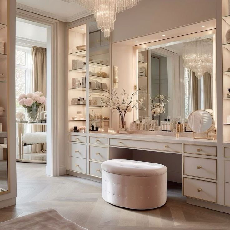 an elegant bathroom with white furniture and chandelier above the vanity, along with large mirrors