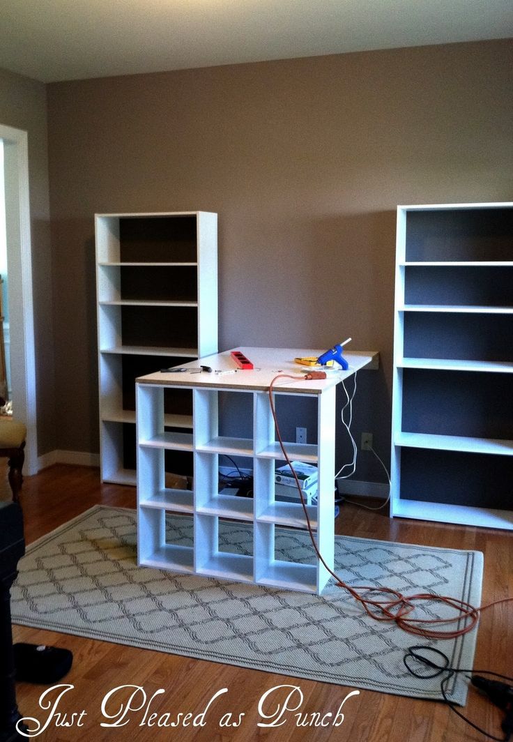 an empty room with bookshelves and a rug on the floor in front of it