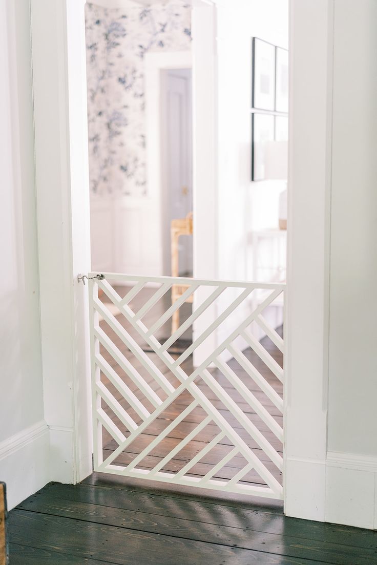 an open door leading into a room with white walls and wood floors, along with a wooden floor