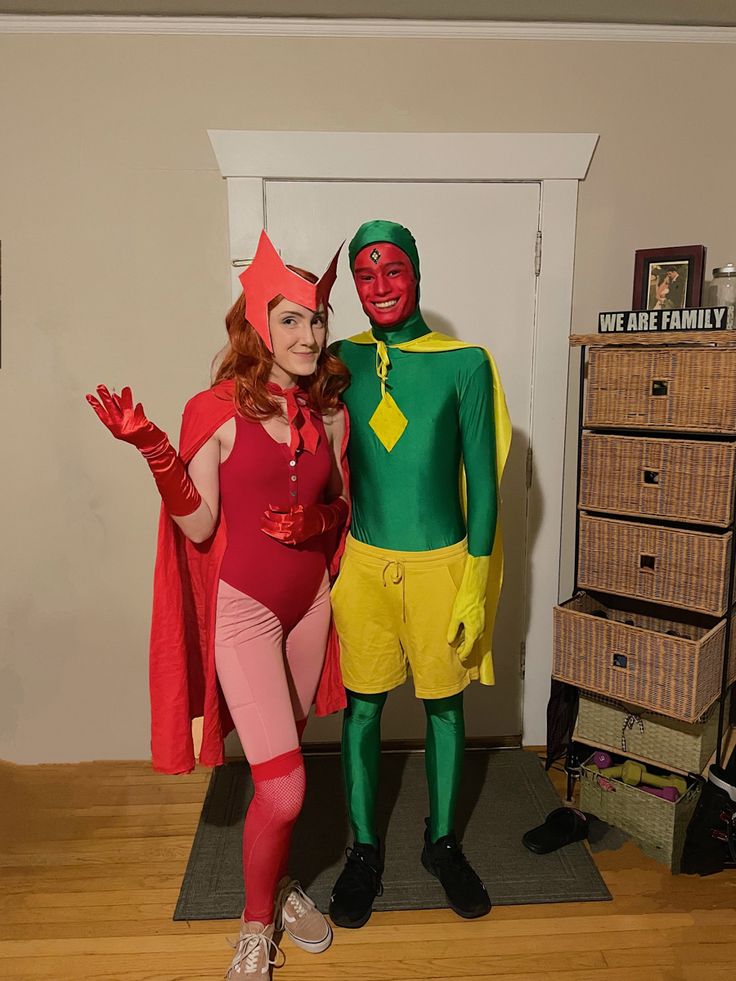 two people in costumes standing next to each other on a wooden floor near a wall