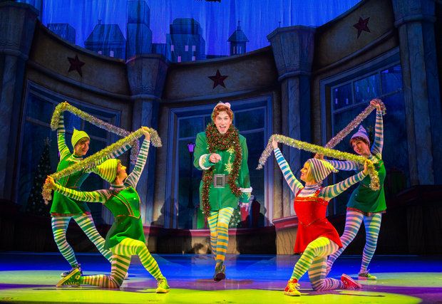 a group of people standing on top of a stage wearing green and yellow outfits,