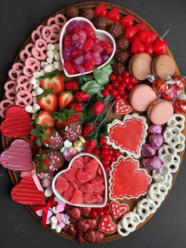 a platter filled with lots of heart shaped cookies and other food on top of it