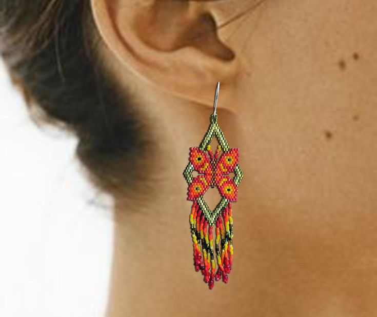 a close up of a woman's ear wearing colorful beaded earrings with flowers