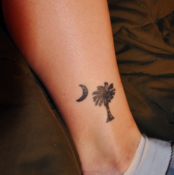 a small palm tree and moon tattoo on the ankle