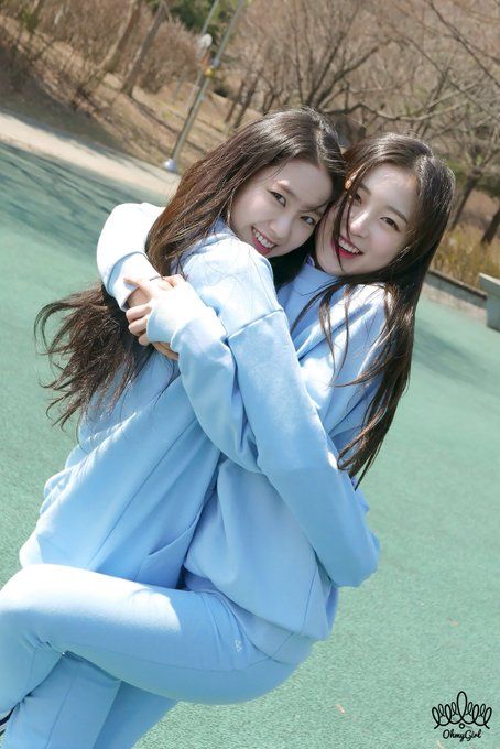 two young women hugging each other on a tennis court