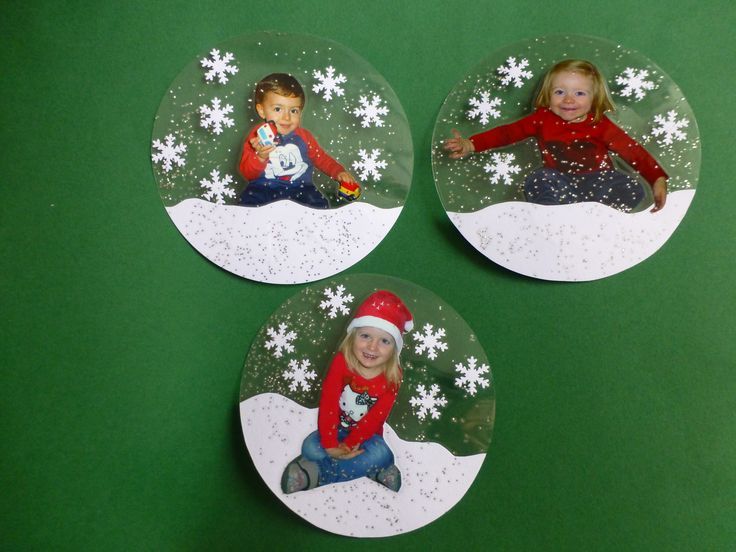 three snow globes with pictures of children in them on green paper and white snowflakes