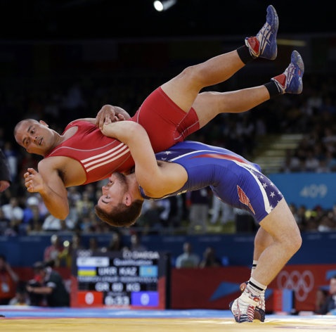 two men are wrestling in an indoor wrestling match