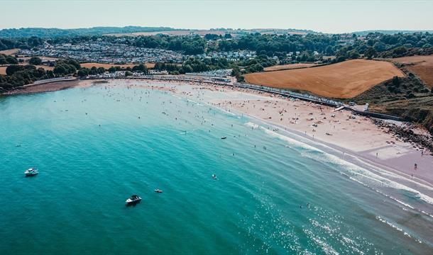 an aerial view of a beach with boats in the water