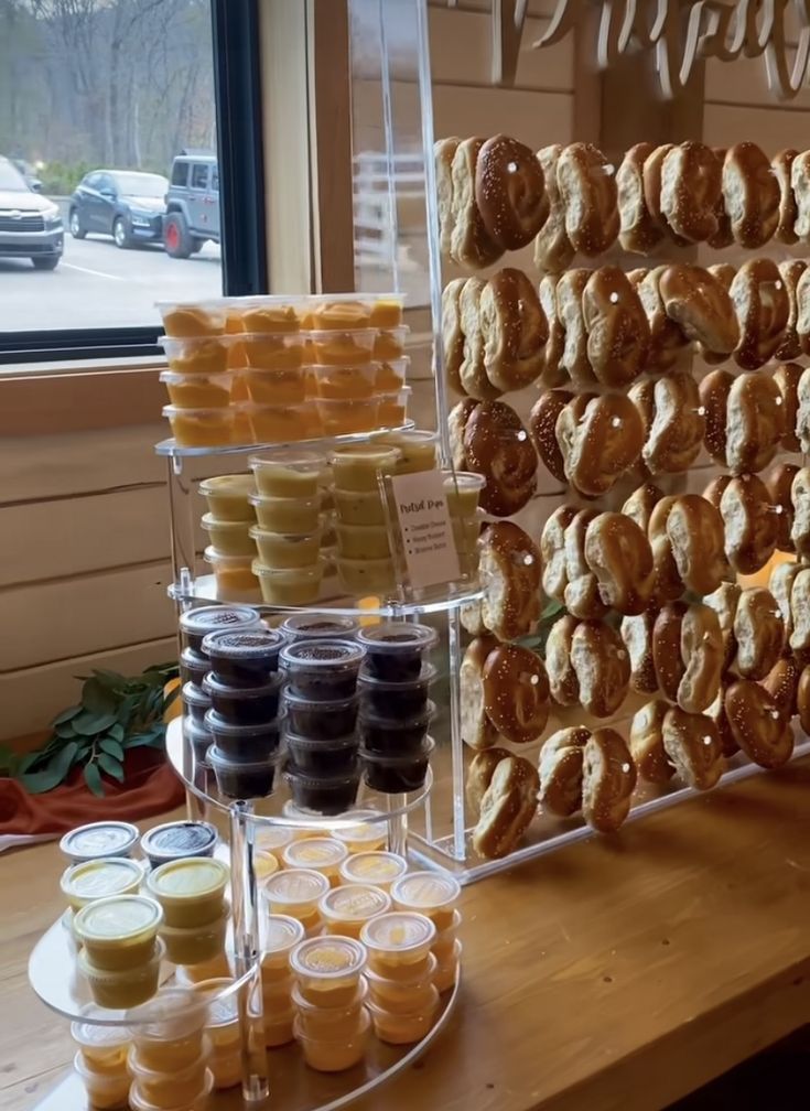 an assortment of pastries and desserts displayed on a table in front of a window