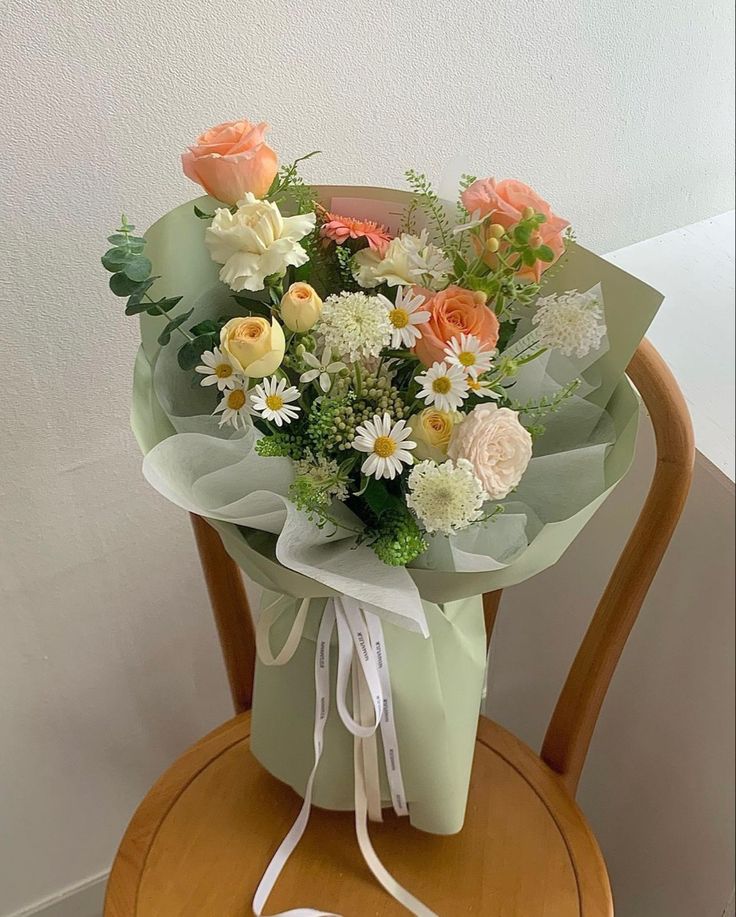 a bouquet of flowers sitting on top of a wooden chair