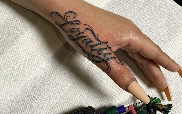 a person's hand with the word faith tattooed on it, next to some crayons