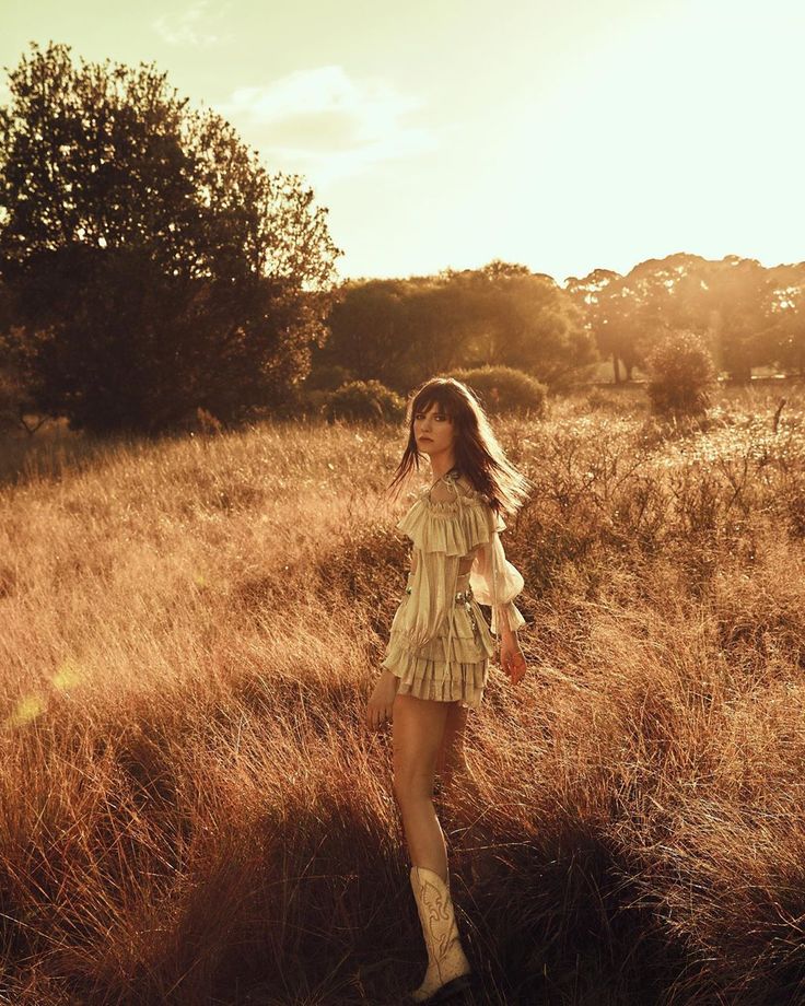 a woman standing in the middle of a field