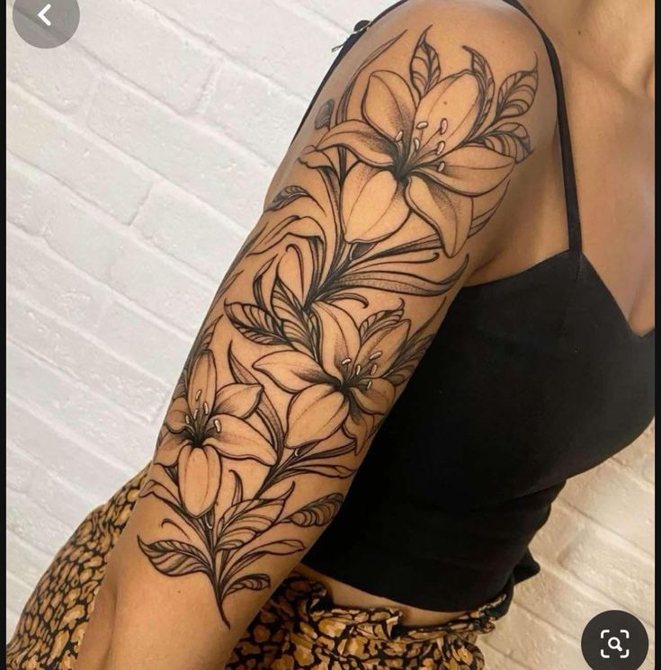 a woman's arm with flowers and leaves tattooed on the side of her body