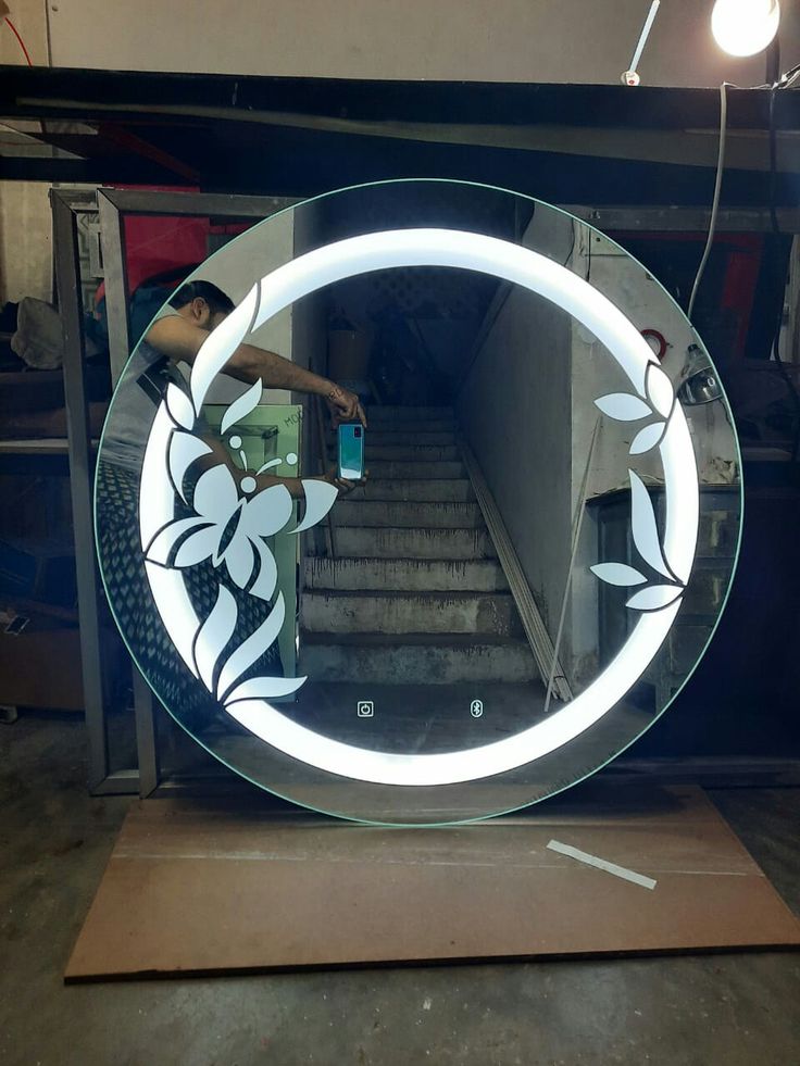 a round mirror sitting on top of a wooden table next to stairs in a building