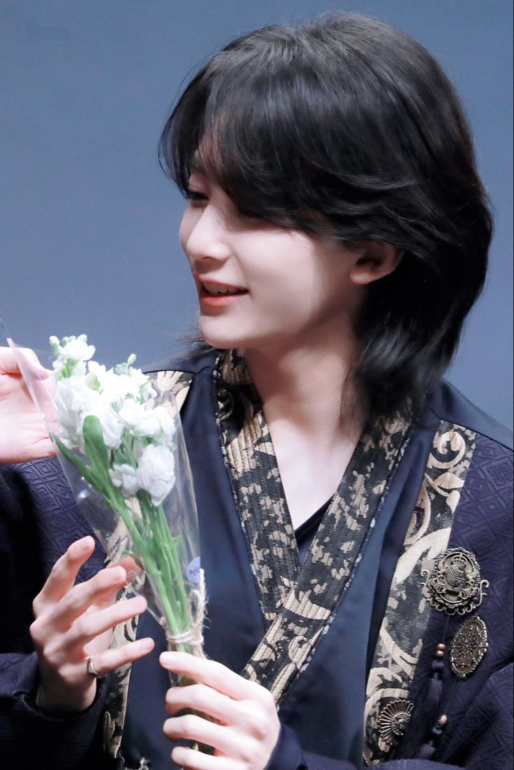 a woman holding a bouquet of white flowers