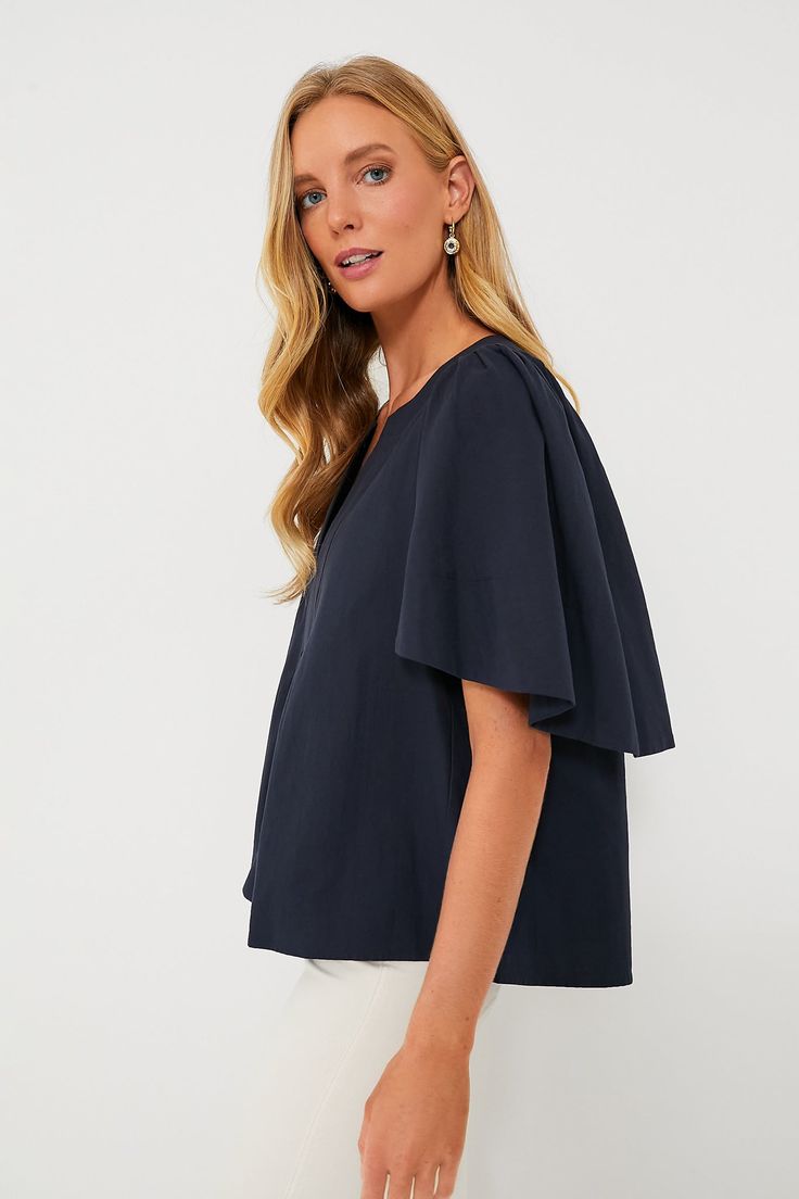 The Finley Flutter Sleeve Top is effortlessly chic. In a classic navy hue, this blouse has a flattering silhouette, oversized flutter sleeves, and a V-neckline that is perfect for year round wear. Pair with gold accessories for everything from work to brunch this season. V-neckline Oversized short flutter sleeves Boxy fit Slightly cropped Material: 100% Cotton Care: Hand wash cold, hang to dry Chic Formal Tops With Ruffle Sleeves, Elegant Flutter Sleeve Blouse For Work, Butterfly Sleeve Tops For Work, Butterfly Sleeve Tops For Workwear, Navy Elegant Tops For Formal Occasions, Elegant Blouse With Butterfly Sleeves, Chic Bell Sleeve Tops For Work, Navy Elegant Formal Tops, Chic Ruffle Sleeve Tops For Work