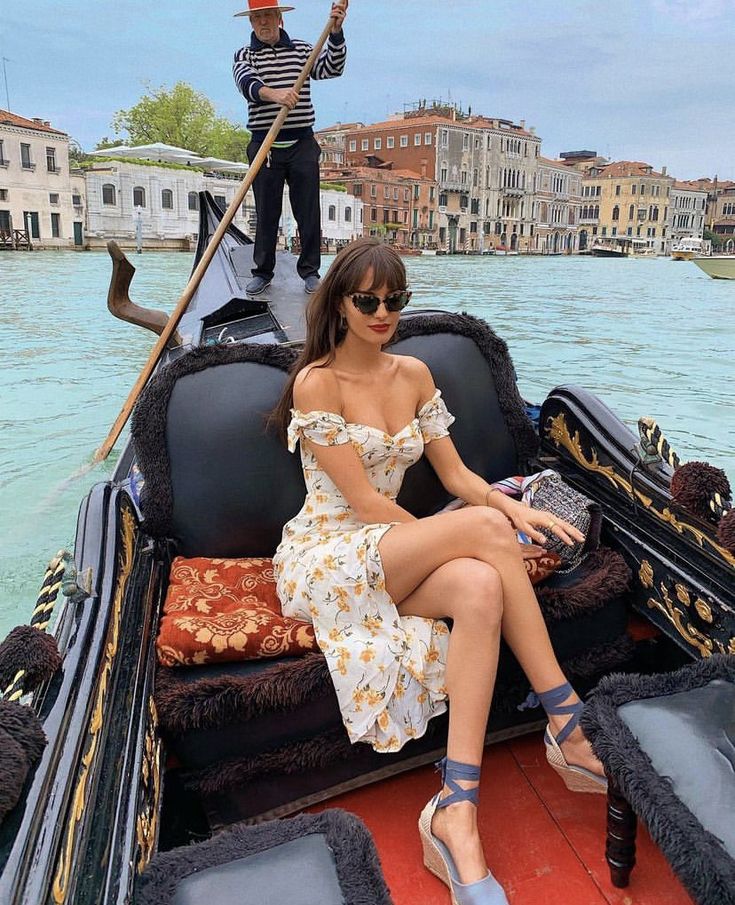 a woman sitting on the back of a gondola with her legs spread out