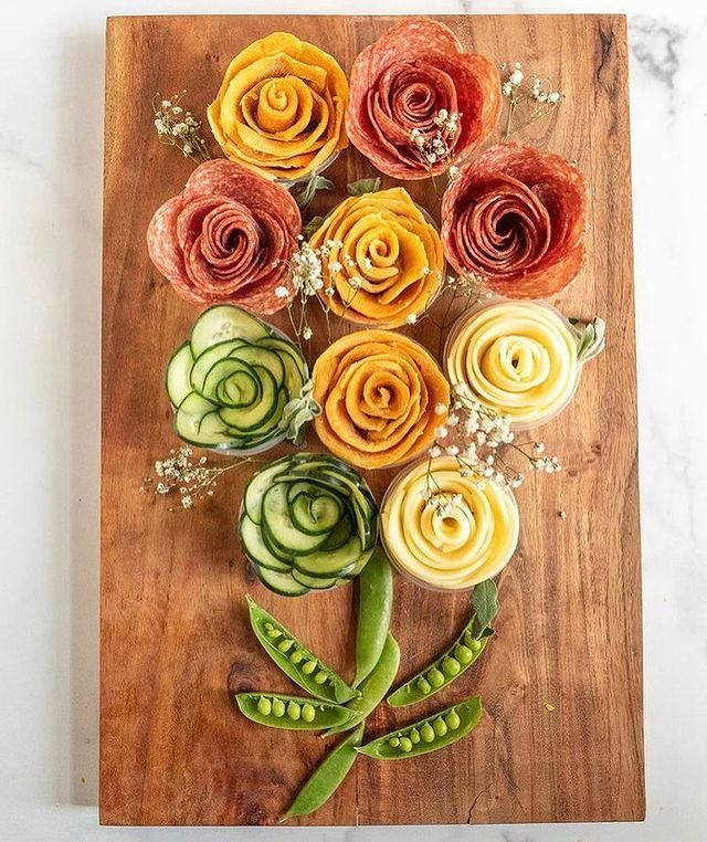 an arrangement of flowers on a cutting board