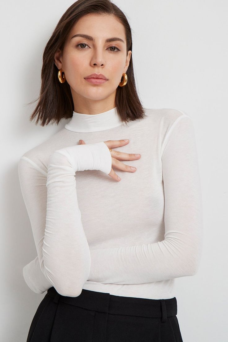 Meet our Sheer Addy Top, the ideal layering piece in our beloved sheer European jersey. She's a mock-neck top crafted from a translucent fabric, cut with a body-hugging fit with extra stretch. Her sleeves are finished with thumbholes for a signature Marcella touch of coziness with edge. Addy is also available in classic jersey.[SPLIT] Julia, in off white, is 5'10" (178 cm) tall, wearing size XS. Maritza, in light beige, is 5'9.5" (177 cm) tall, wearing size XS. Steph, in black, is 5'11" (180 cm) White Sheer Top, Autumn T Shirts, Red Maxi, Top Crafts, Mock Neck Top, Long Sleeve Turtleneck, Winter Clothing, Solid Clothes, 가을 패션