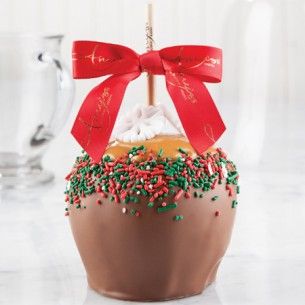 a chocolate covered cake with sprinkles and a red bow on top is sitting on a table