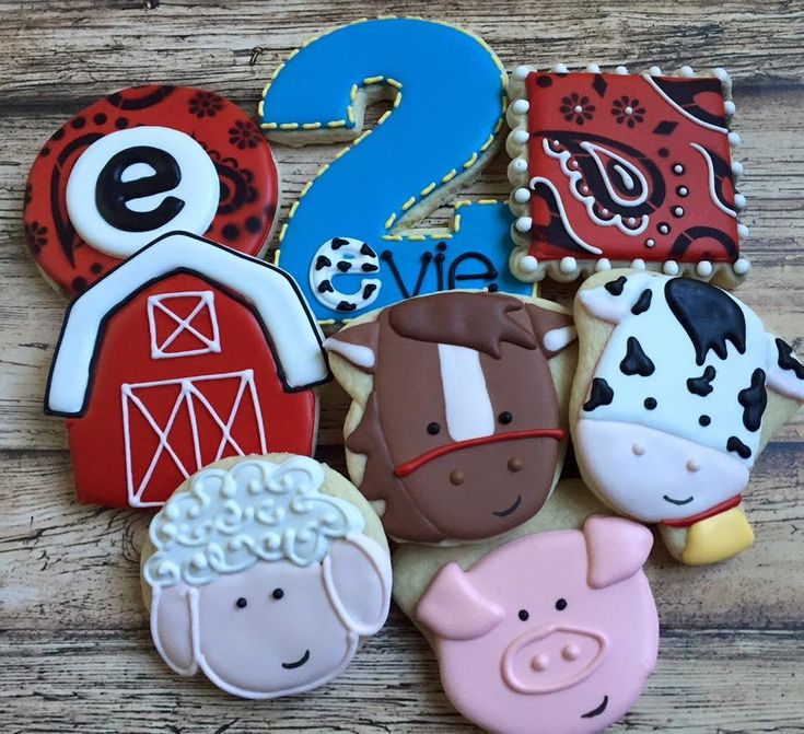 decorated cookies with farm animals and numbers are on a wooden table, ready to be eaten