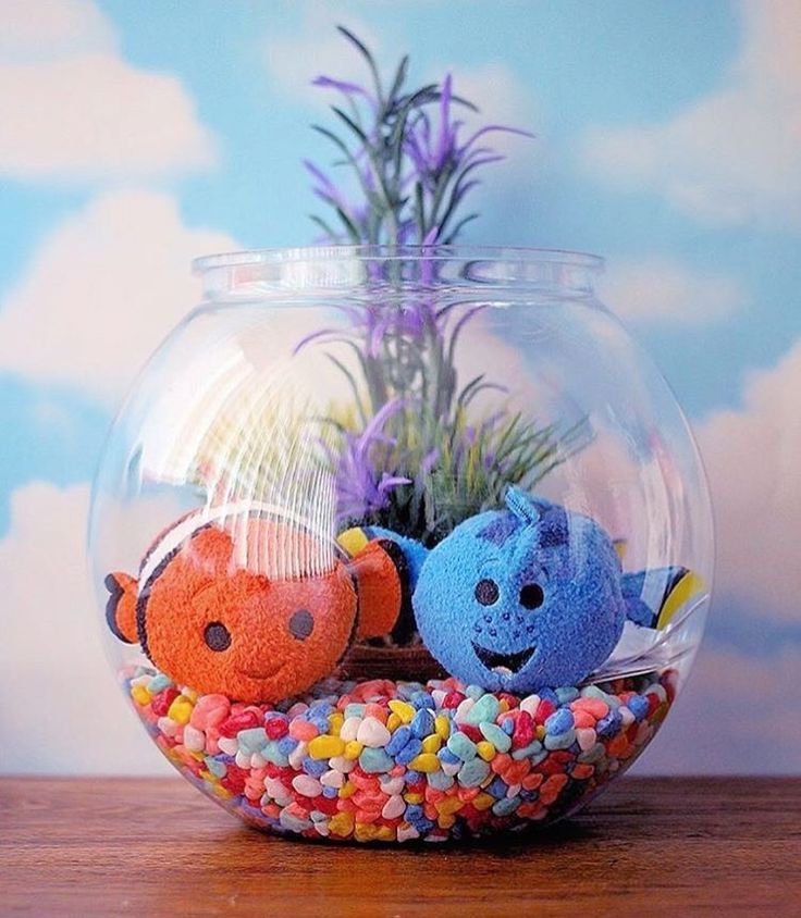 two stuffed animals are sitting in a fish bowl