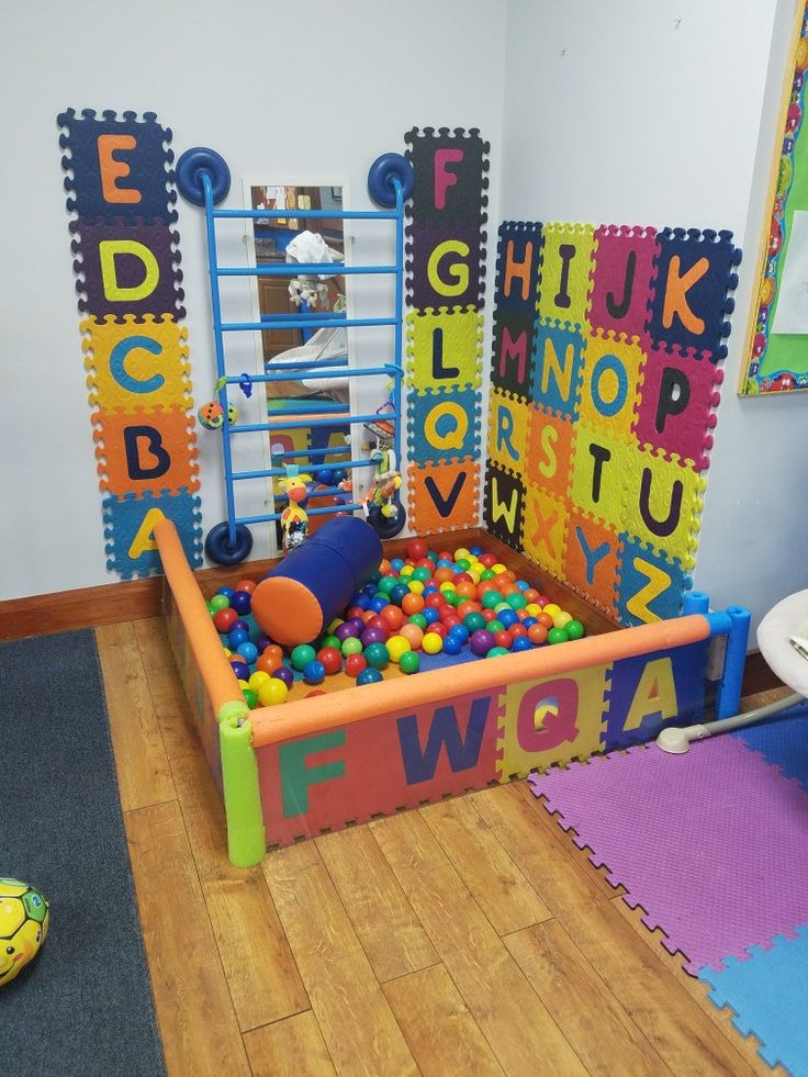 a child's play room with toys and letters on the walls, flooring