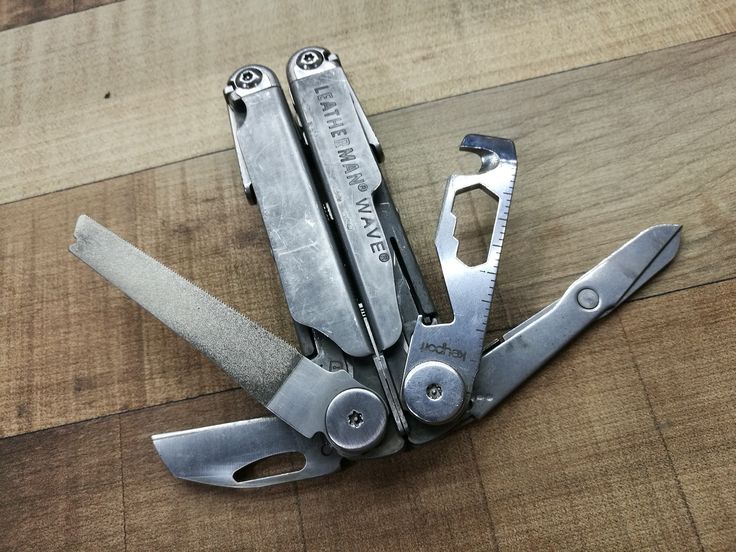 a pair of pliers on top of a wooden table next to a wrench