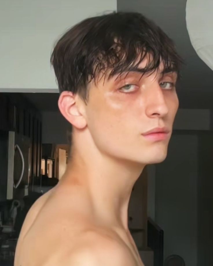 a young man with no shirt is staring at the camera