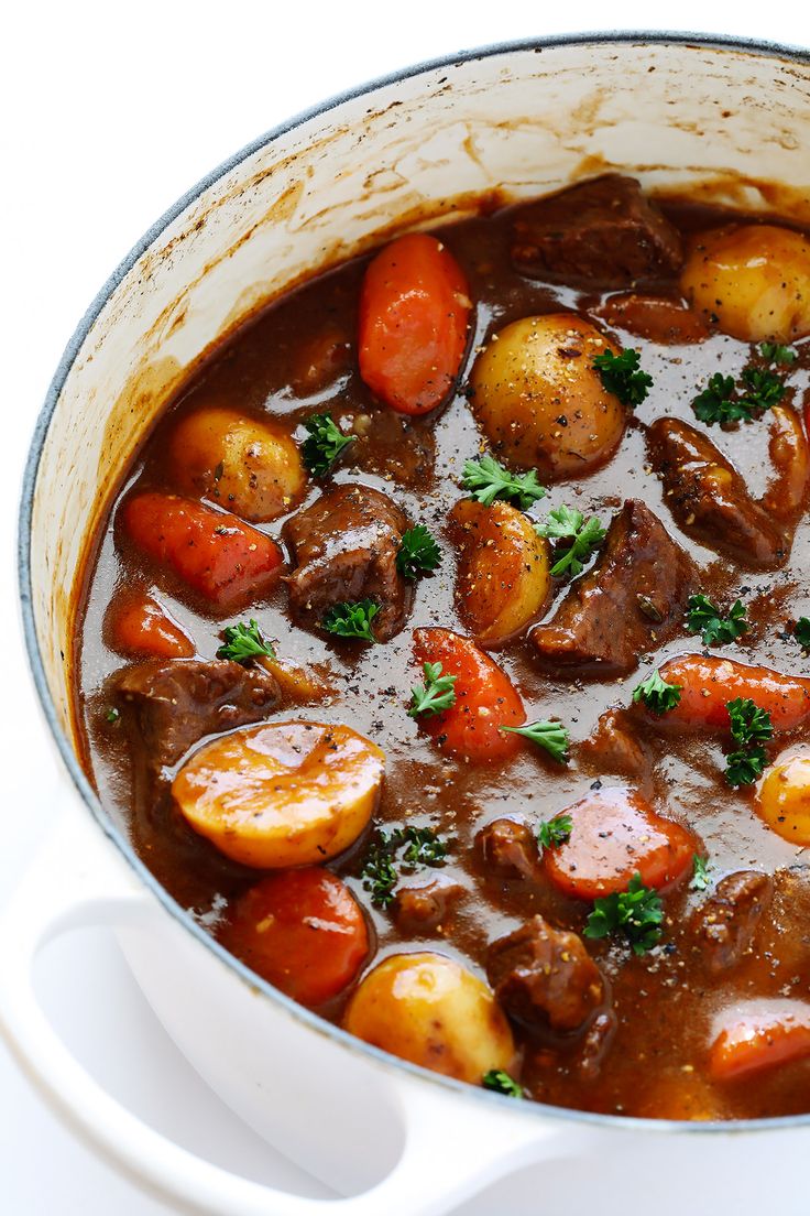 a pot filled with stew and vegetables on top of a table