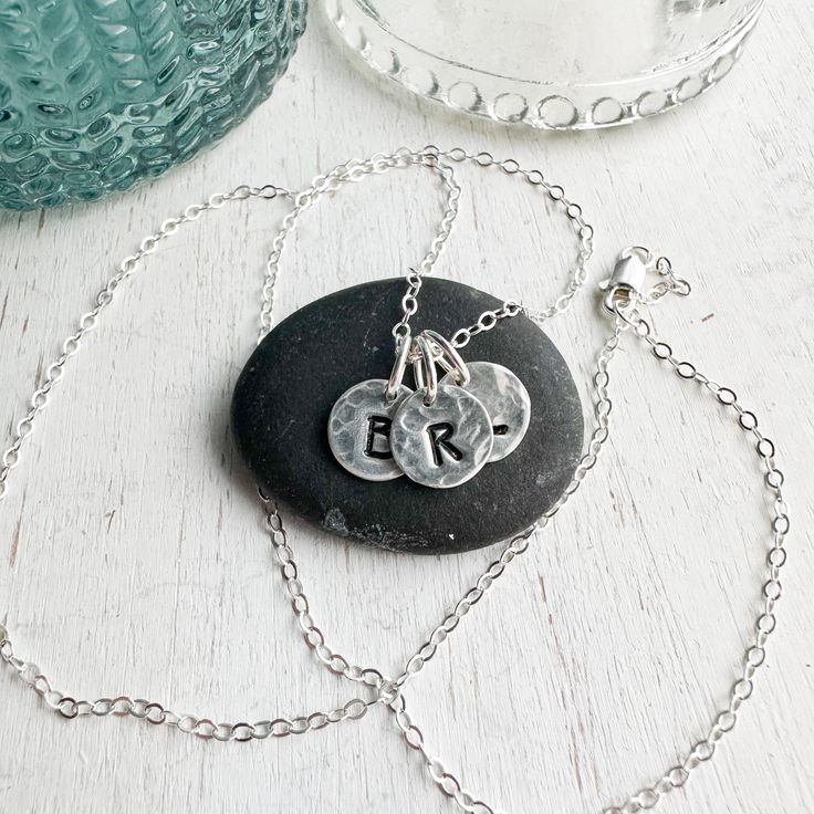 Sterling silver keepsake Initial necklace. Small circle charms are textured and stamped with the letters that mean the most to your heart. Add your initials in the order notes box at checkout. Solid sterling silver charms 1/4 wideSterling silver cable chain. Pieces Of Her, Light Grid, Initials Necklace, Silver Initial Charms, 5 Star Review, Sterling Silver Initial, Small Circle, Note Box, Initial Charm