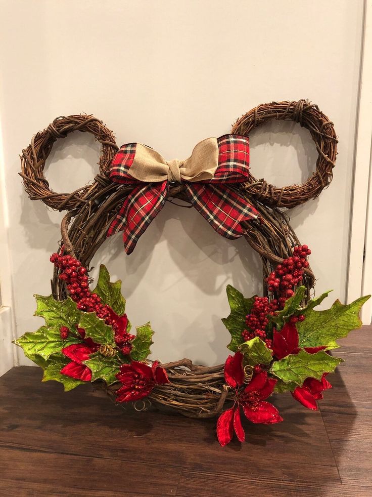 a mickey mouse wreath with poinsettis and holly